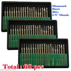 four sets of diamond drill bits in black trays with white lettering on the bottom