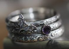 I made this set of 3 intricately patterned  solid sterling silver patterned rings with a sweet little vampire bat, also sterling.  I added a beautiful little genuine 4mm amethyst encased in a serrated sterling bezel.  Widths of bands vary from 2.4mm-3.5mm. SIZING HINT:  I'd advise ordering 1/2 size up for this or any multiple ring stack if you want to wear them all together.  It's much more comfortable to wear. The sterling silver has been darkened/antiqued then polished to bring out the pattern Ring Vampire, Bat Ring, Nose Ring Jewelry, Vampire Bat, Stacking Ring Set, Gothic Rings, Pattern Ring, Bridal Ring Sets, Pretty Jewelry