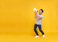 a young man is playing with an object on a yellow background