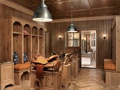 a room filled with lots of wooden furniture next to a horse shoe rack and light fixture