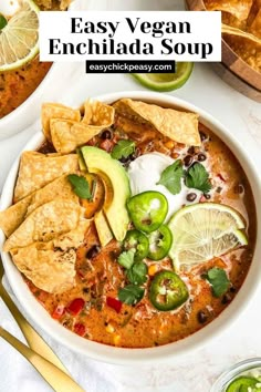 easy vegan enchilada soup in a white bowl with tortillas and limes