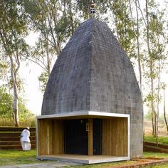 a small building with a wooden door in the grass