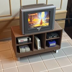 a small tv sitting on top of a wooden shelf