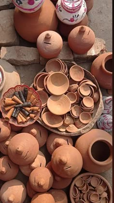 many clay pots and bowls are on the ground