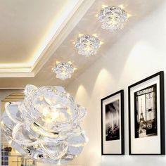 a chandelier hanging from the ceiling in a room with pictures on the wall