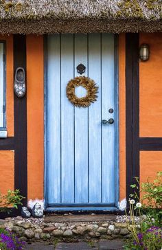 an orange and blue house with a wreath on the front door