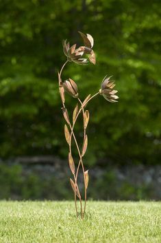 a tall metal plant is in the grass