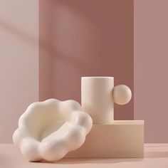 a white vase sitting on top of a table next to a cup and saucer