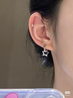 a close up of a person's ear with an earring in the shape of a star