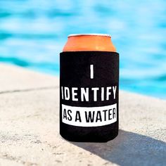 an orange and black can cooler sitting next to a swimming pool with the words identity as a water on it