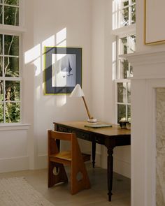 a room with a desk, chair and painting hanging on the wall next to it