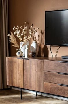 a flat screen tv sitting on top of a wooden dresser