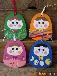 three colorful wooden tags hanging from a wood plank with string attached to them, each featuring two different faces