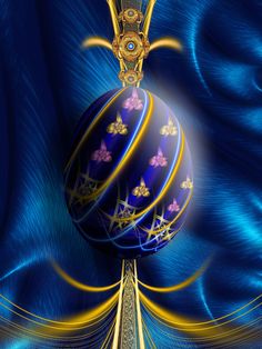 a blue and gold decorated egg on top of a metal pole in front of a blue curtain