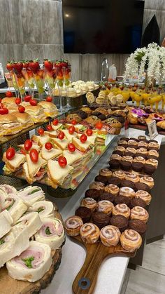 an assortment of pastries and desserts on display in a buffet style setting at a restaurant