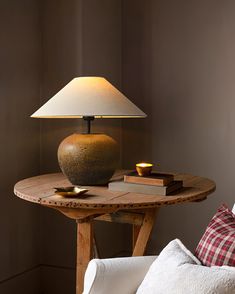 a lamp sitting on top of a wooden table next to a white couch in a living room