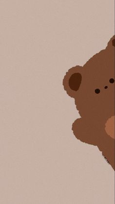 a brown teddy bear sitting up against a wall