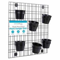 the wall mounted plant hanger grid has four pots attached to it and is black