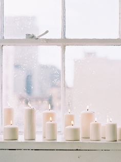 candles are lined up in front of a window