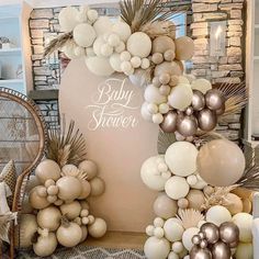 a baby shower is decorated with balloons and palm leaves