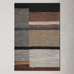 a multicolored rug hanging on the wall in front of a white wall and floor