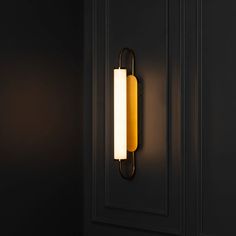 a wall light that is on the side of a black door in a dark room