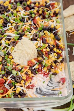 a casserole dish with tortilla chips and black olives