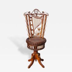 a wicker chair with an ornate design on the back and foot rests on a wooden stand