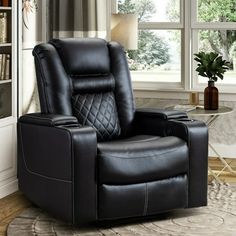 a black recliner chair sitting in front of a window