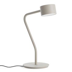 a white table lamp with a light on it and a cord attached to the base