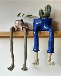 three different types of planters are hanging on the wall, one is shaped like a human legs