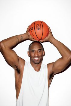 a man holding a basketball over his head with both hands on top of his head