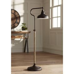 the floor lamp is standing on top of a wooden floor in front of a window