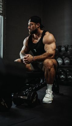 a man squatting on a bench in the gym