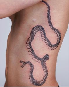 a man's stomach with a snake tattoo on it