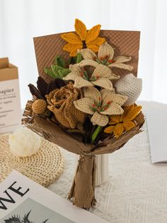 a bouquet of flowers sitting on top of a table next to a book and magazine