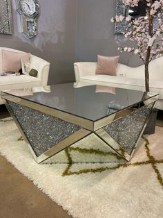 a glass coffee table sitting on top of a white rug