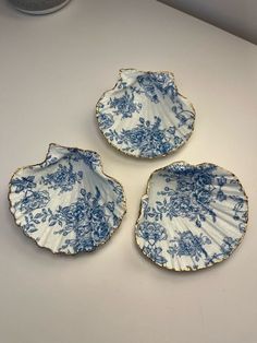 three blue and white plates sitting on top of a table