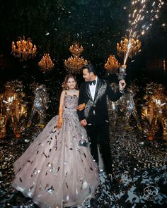 a man and woman dressed in formal wear are walking through confetti covered ground