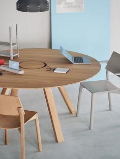 a wooden table with two chairs and a laptop on it