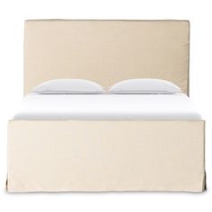 a bed with two pillows on top of it and a white blanket over the headboard