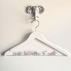 a white wooden hanger with the word too cool on it and an elephant head