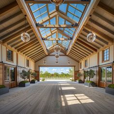 the inside of a large building with lots of windows and wooden flooring on both sides