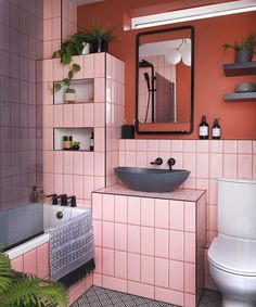 a bathroom with pink tiles and black accents