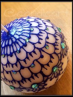 a blue and white vase sitting on top of a wooden table next to a candle