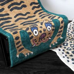 a chair with a leopard print on it and two rugs in front of it