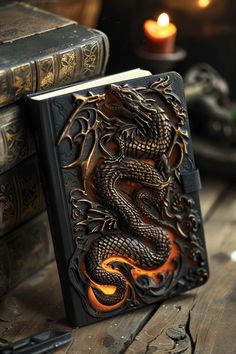 a book with a dragon carved into it sitting on a table next to some books