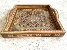 a decorative wooden tray sitting on top of a floor