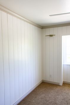 an empty room with white walls and carpet