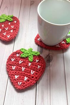 crocheted coasters with strawberries on them sitting next to a coffee cup